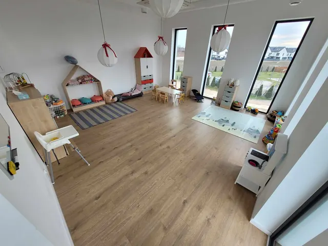 Sala żłobkowa z domkiem, zabawkami i krzesełkami do karmienia